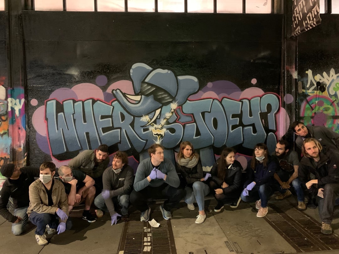 Pachyderm team posing in front of graffiti mural